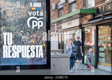 Fußgänger gehen an einer Werbung der Partei Partido Popular (PP) für die bevorstehenden Europawahlen am 9. Juni in Madrid vorbei. Stockfoto