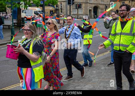 Menschen feiern bei einer Veranstaltung im Freien mit bunten Kleidern und Streamern in einer Pride-Prozession mit dem Bürgermeister von Calne Cllr Jon Fisher am 1. Juni 2024 Stockfoto