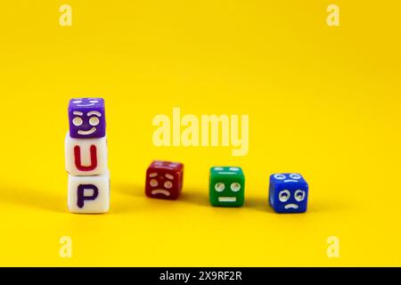 Happy Cube on Word Up neben anderen Cubes mit traurigen Ausdrücken Stockfoto