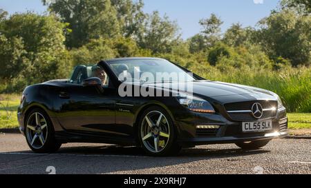 Stony Stratford, UK - 2. Juni 2024: 2015 schwarzer Mercedes Benz amg slk 55 Auto fährt auf einer britischen Landstraße Stockfoto