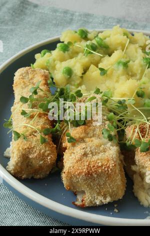 Hausgemachte Fischstäbchen mit Kartoffelpüree und Erbsen Stockfoto