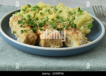 Hausgemachte Fischstäbchen mit Kartoffelpüree und Erbsen Stockfoto