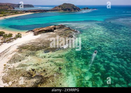 Blick aus der Vogelperspektive auf traditionelle Boote, die in einem warmen, flachen Meer vor einem tropischen Strand liegen (Tanjung aan, Lombok, Indonesien) Stockfoto
