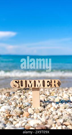 Hölzernes Sommerschild am wunderschönen felsigen Strand Stockfoto