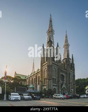 Jakarta, Indonesien - 8. Mai 2024. Jakarta Kathedrale, eine neogotische römisch-katholische Kathedrale, mit Autos im Vordergrund. Die Kathedrale hat TW Stockfoto