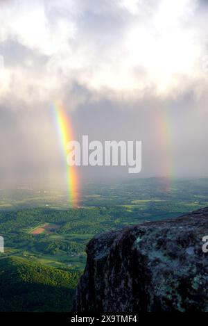 Ein Regenbogen ist vom Gipfel des Sharp Top Mountain bei Sonnenuntergang in den Blue Ridge Mountains in Virginia zu sehen Stockfoto