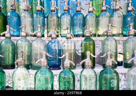 Retro-farbene Soda-Wasserflaschen zum Verkauf auf dem sonntäglichen Flohmarkt von San Telmo in Buenos Aires. Stockfoto