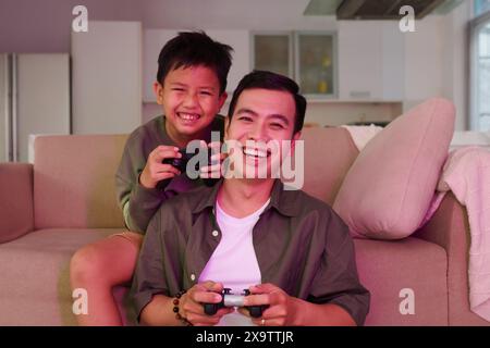 Glücklich aufgeregt Vater und Sohn spielen zu Hause Videospiele Stockfoto
