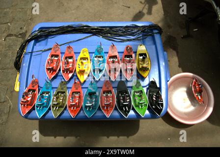 Auf einem Straßenmarkt in Jatinegara, East Jakarta, Jakarta, Indonesien, werden Boote für Kinder aus Metall verkauft. Stockfoto