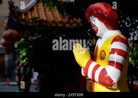 Beleuchtet vom Morgenlicht, der berühmte McDonald's Clown in einem McDonald's Fast Food Outlet in Bangkok, Thailand, führt den traditionellen thailändischen Gruß ( Stockfoto