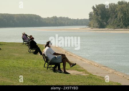 Menschen sitzen auf Bänken auf der Donau in Apatin, Vojvodina, Serbien Stockfoto