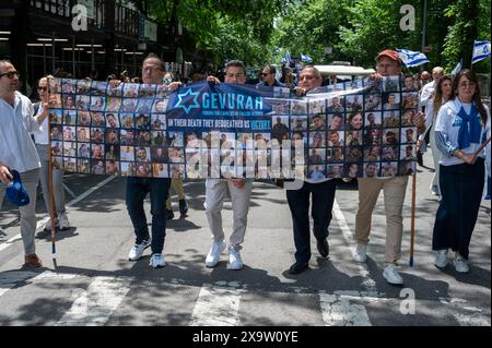 NEW YORK, NEW YORK - 2. JUNI: Menschen, die einen baner mit Bildern gefallener IDF-Soldaten halten, marschieren während der jährlichen Feiern-Israel-Parade am 2. Juni 2024 in New York City auf die Fifth Avenue. Zehntausende von Menschen marschierten während einer Parade für Israel auf die Fünfte Avenue, wobei viele zur Freilassung von Geiseln, die von der Hamas in Gaza festgehalten wurden, aufriefen: "Bring sie nach Hause", eine Botschaft, die laut und deutlich ertönte. Die Parade fand fast acht Monate nach dem beispiellosen Angriff der Hamas am 7. Oktober statt, dem tödlichsten in der Geschichte Israels. Das NYPD erhöhte die Sicherheit für die Parade aufgrund von Spannungen und Protesten rund um die Stockfoto