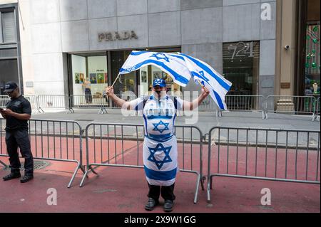 NEW YORK, NEW YORK - 2. JUNI: Ein Mann mit israelischen Flaggen nimmt an der jährlichen Feiern-Israel-Parade am 2. Juni 2024 in New York Teil. Zehntausende von Menschen marschierten während einer Parade für Israel auf die Fünfte Avenue, wobei viele zur Freilassung von Geiseln, die von der Hamas in Gaza festgehalten wurden, aufriefen: "Bring sie nach Hause", eine Botschaft, die laut und deutlich ertönte. Die Parade fand fast acht Monate nach dem beispiellosen Angriff der Hamas am 7. Oktober statt, dem tödlichsten in der Geschichte Israels. Die NYPD erhöhte die Sicherheit für die Parade aufgrund von Spannungen und Protesten rund um den Krieg in Gaza. Stockfoto