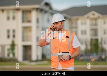 Ernsthafter Ingenieur im neuen Zuhause. Bauleiter im Helm. Architekt auf einer Baustelle. Handwerker-Baumeister im Hardhelm. Gebäudekonzept. Builder Stockfoto