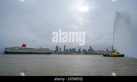 Cunards Queen Anne segelt in die Mersey, begleitet von Feuerschleppern, vor einer Namenszeremonie am Liverpool Pier Head, als Teil einer einführenden „Runde der Ehre“-Reise um die britischen Inseln. Bilddatum: Montag, 3. Juni 2024. Stockfoto