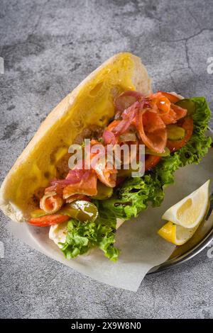 Sandwich mit geräuchertem Lachs auf Metallteller auf Steintisch Stockfoto