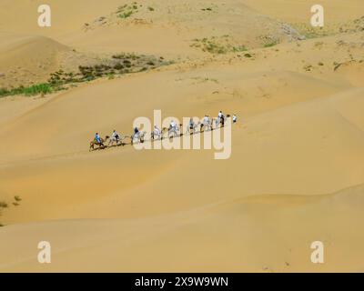 Ordos, China. Juni 2024. Am 31. Mai 2024 reiten Touristen auf Kamelen am malerischen Ort Yinkantara in der Kubuqi-Wüste in Ordos, der autonomen Region der Inneren Mongolei, China. (Foto: Costfoto/NurPhoto) Credit: NurPhoto SRL/Alamy Live News Stockfoto