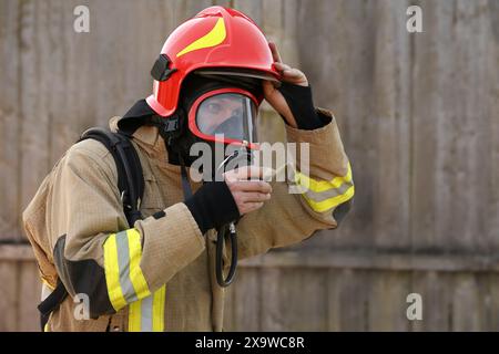 Feuerwehrmann in Uniform mit Helm und Maske im Freien Stockfoto