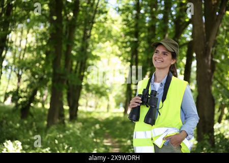 Forstwirt mit Fernglas untersucht Pflanzen im Wald, Raum für Text Stockfoto