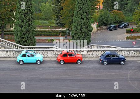 FLORENZ, ITALIEN - 13. SEPTEMBER 2019: Auf einer Stadtstraße befinden sich drei bunte alte Fiat 500-Autos. Stockfoto