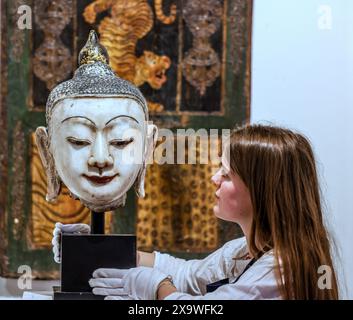 Olympia Auctions, London, Großbritannien. Juni 2024. Ein geschnitzter und bemalter Marmorkopf von Buddha, Burma, um 1900mit langen Ohrläppchen, rot bemalten Lippen und schwarz bemalten gewölbten Augenbrauen, eng gelockten schwarz bemalten Haaren und Usnisa mit knospenförmigem Finial, montiert, 43 cm hohe Provenienz: Privatsammlung, Kensington, London Est £1,000-1,500 Auktion 5. Juni 2024. Quelle: Paul Quezada-Neiman/Alamy Live News Stockfoto