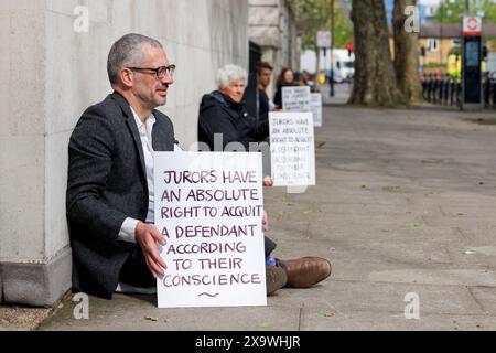 Mai 2023. Inner London Crown Court, Southwark, Großbritannien. Tim Crosland, ehemaliger Rechtsanwalt und Direktor von Plan B, riskiert zum zweiten Mal vor dem Inner London Crown Court eine Verachtung des Gerichts. Eine Gruppe von 24 Personen, darunter 7 medizinische Fachkräfte, 3 Quäker, ein ehemaliger Anwalt, ein ehemaliger Polizeibeamter, ein Priester der Church of England und 2 Lehrer, sitzen schweigend auf der Straße um den Gerichtshof herum und solidarisieren sich mit den Angeklagten des britischen Klimaprotestes, denen es verboten ist, über ihre Motive zu sprechen oder während ihrer Prozesse die Worte „Klimawandel“ oder „Brennstoffarmut“ zu verwenden. Stockfoto