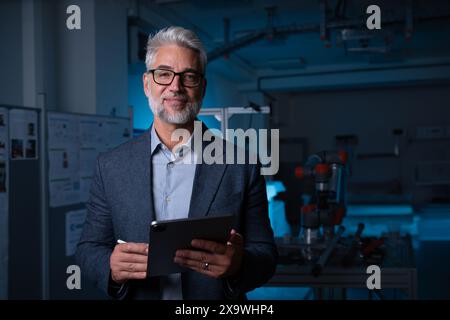Porträt eines Roboteringenieurs, der am mechanischen System des Roboterarms arbeitet. Konzept der modernen Technologie in Branchen, automatisierten Prozessen, Automobilindustrie Stockfoto