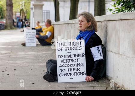 Mai 2023. Inner London Crown Court, Southwark, Großbritannien. Eine Gruppe von 24 Personen – 7 Ärzte, 3 Quäker, ein ehemaliger Anwalt, ein ehemaliger Polizist, ein Priester der Kirche von England, zwei Lehrer und zehn weitere sitzen schweigend auf der Straße um den Gerichtshof herum, in Solidarität mit den Beschuldigten des britischen Klimaprotestes, denen es verboten ist, über ihre Beweggründe zu sprechen oder während ihrer Gerichtsverfahren die Worte „Klimawandel“ oder „Brennstoffarmut“ zu verwenden. Dr. Juliette Brown, 52, eine Psychiaterin und Sprecherin der Ärzte für XR, sagte: „Wir sind gewöhnliche Menschen, die sich um unsere Sicherheit, Sicherheit, Gesundheit, die sorgen Stockfoto