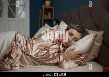Schlaflose verärgerte alte Frau, die im Bett liegt und an Schlaflosigkeit leidet Stockfoto