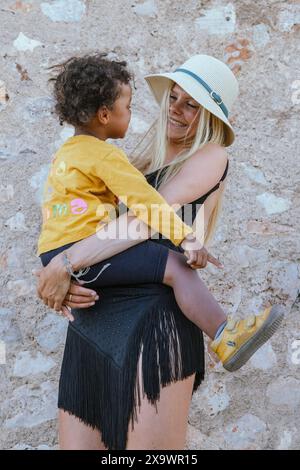 Glückliche, schöne Mutter, die ihren Sohn hängt, Familienszene Spanien Stockfoto