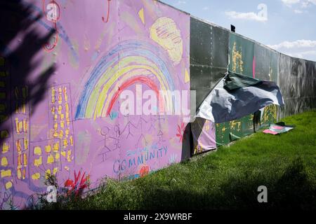 Eine Landschaft aus einem Umkreis, der Brockwell Park während des Mighty Hoopla Festivals für die LGBTQ+ Community am 2. Juni 2024 in London umgibt. Eine Kinderzeichnung zeigt einen Regenbogen, spielende Kinder und eine ironische Botschaft über die „Inclusive Community“, die die Nutzung von Grünflächen für private Unternehmen durch den Rat von Lambeth hervorhebt, gegen die Gemeinderäte öffentliche Parks übergeben, die sonst für viele Wochen vor und nach der Veranstaltung genutzt werden. Stockfoto