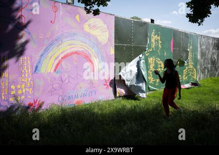 Eine Landschaft aus einem Umkreis, der Brockwell Park während des Mighty Hoopla Festivals für die LGBTQ+ Community am 2. Juni 2024 in London umgibt. Eine Kinderzeichnung zeigt einen Regenbogen, spielende Kinder und eine ironische Botschaft über die „Inclusive Community“, die die Nutzung von Grünflächen für private Unternehmen durch den Rat von Lambeth hervorhebt, gegen die Gemeinderäte öffentliche Parks übergeben, die sonst für viele Wochen vor und nach der Veranstaltung genutzt werden. Stockfoto