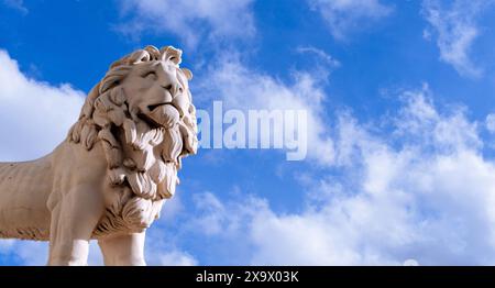 Die weiße Steinstatue eines Löwen steht am blauen Sommerhimmel am South Bank, London Stockfoto