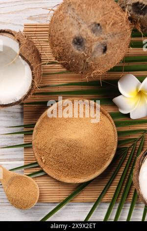 Kokosnusszucker, Palmblätter, Früchte und Bambusmatte auf rustikalem Holztisch, flache Ladefläche Stockfoto