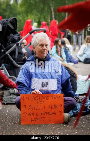 Mai 2023, Tate Modern, London, UK. XR Familien und Gesundheit, Mütteraufstand protestieren mit Roten Rebellen und Sanitätern. Stockfoto