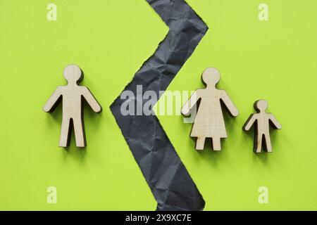 Geteilte Familienfiguren und ein zerrissenes Blatt als Symbol der Scheidung. Stockfoto