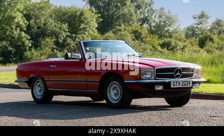 Stony Stratford, UK - 2. Juni 2024: 1980 roter Mercedes Benz 450 sl Oldtimer auf einer britischen Landstraße Stockfoto