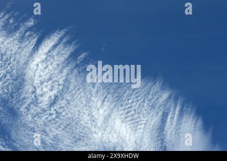 Wolkenschwaden in großer Höhe bilden ein markantes Muster am Himmel. Sie wird durch Eiskristalle in großer Höhe gebildet und oft mit Zirren assoziiert Stockfoto