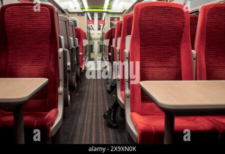 Ein leerer Zugwagen mit nur einem Paar Damenstiefel, der von einem der Sitze auf der London-Leeds-Linie hinausragt. Stockfoto