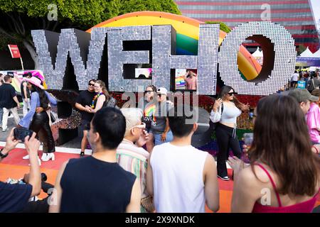 Los Angeles, USA. Juni 2024. Leute, die während der WeHo Pride Street Fair in West Hollywood, Kalifornien, am Sonntag, den 2. Juni 2024, Fotos vom WeHo Pride-Schild machen. (Foto: Caylo Seals/SIPA USA) Credit: SIPA USA/Alamy Live News Stockfoto