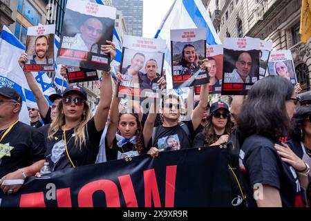 New York, Usa. Juni 2024. Familien der Geiseln, die am 7. Oktober genommen wurden, führen die Parade mit einem „Bring sie jetzt nach Hause“-Banner und Postern ihrer Lieben an. Die 59. Jährliche Israel Day-Parade marschiert die 5th Avenue entlang des Central Park. Die Parade feiert die israelische Kultur und den Stolz. Die Parade nahm in diesem Jahr einen düsteren Ton an, während der Krieg zwischen Israel und der Hamas stattfand, wobei der Hauptaugenmerk darauf lag, die verbleibenden 120 Geiseln, die noch immer in Gaza waren, nach Hause zu bringen, die am 7. Oktober 2023 entführt wurden. Quelle: SOPA Images Limited/Alamy Live News Stockfoto
