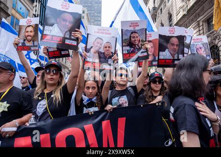 Familien der Geiseln, die am 7. Oktober genommen wurden, führen die Parade mit einem „Bring sie jetzt nach Hause“-Banner und Postern ihrer Lieben an. Die 59. Jährliche Israel Day-Parade marschiert die 5th Avenue entlang des Central Park. Die Parade feiert die israelische Kultur und den Stolz. Die Parade nahm in diesem Jahr einen düsteren Ton an, während der Krieg zwischen Israel und der Hamas stattfand, wobei der Hauptaugenmerk darauf lag, die verbleibenden 120 Geiseln, die noch immer in Gaza waren, nach Hause zu bringen, die am 7. Oktober 2023 entführt wurden. (Foto: Syndi Pilar / SOPA Images/SIPA USA) Stockfoto