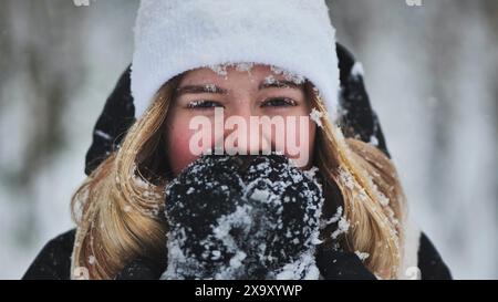 Ein junges Mädchen friert im Winter im Wald. Stockfoto