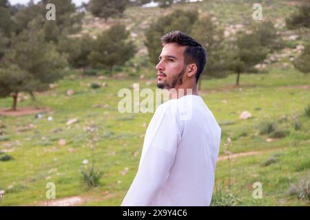 Ein arabisches Volk genießt ein Frühlingspicknick auf einer Wiese in der Nähe von Abu Dhabi. Sie sitzen auf Stühlen und genießen Kaffee unter blauem Himmel mit verstreuten Wolken Stockfoto