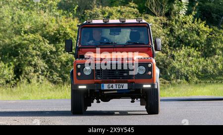 Stony Stratford, Großbritannien - 2. Juni 2024: 2003 orange Land Rover Defender 90 G4 le Oldtimer auf einer britischen Landstraße Stockfoto