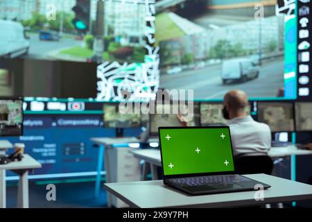 Verschiedene Mitarbeiter überwachen die Routen von Lieferwagen mit einem Laptop mit isoliertem Bildschirm und folgen alternativen Routen auf Satellitenkarte und Radar. Verschiedene Mitarbeiter arbeiten an der Auftragsverfolgung. Stockfoto