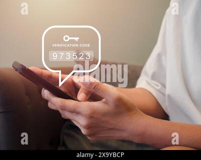 Zwei-Schritte-Authentifizierung oder 2FA-Konzept. Verifizierungscode-Nummern mit Schlüsselsymbol werden angezeigt, wenn eine weibliche Person in weißem Hemd das Smartphone für verwendet Stockfoto