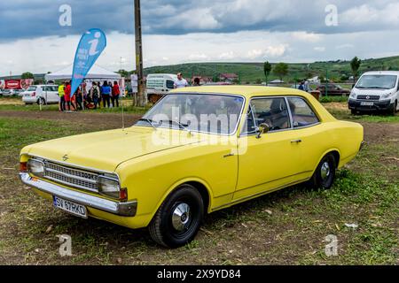 Ein gelber Oldtimer, der auf Gras in der Nähe eines Treffens in Iasi, Rumänien, geparkt wurde Stockfoto