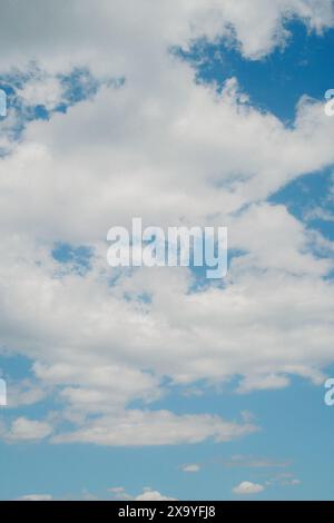 Ein malerischer Blick auf weiße flauschige Wolken am blauen Himmel an einem sonnigen Tag Stockfoto