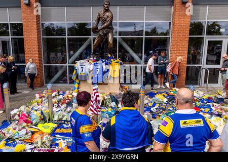 Leeds, Großbritannien. Juni 2024. Tribut an Rob Burrow im Headingley Stadium nach seinem Tod. Drei Fans, die Leeds Rhinos Shirts tragen, bewundern die Tribut kurz nachdem sie Rugbyshirts am Tatort platziert hatten. Quelle: Neil Terry/Alamy Live News Stockfoto